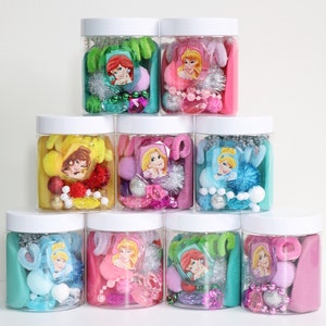 May include: Eight clear plastic jars with white lids filled with various colorful craft supplies, including pom poms, beads, and glitter. Each jar features a different Disney princess character sticker.