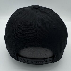 Puede incluir: Gorra de b&eacute;isbol negra con una correa ajustable negra y una parte inferior gris.
