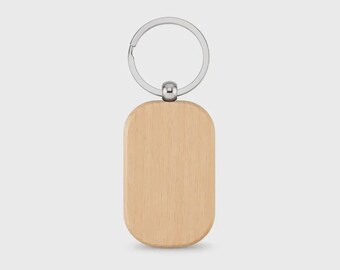 Puede incluir: Un llavero de madera de color claro con un colgante de madera liso de forma ovalada orientado verticalmente, unido a una anilla de metal plateado mediante una pequeña pieza de conexión de metal plateado pulido.