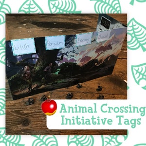 May include: A tabletop gaming accessory featuring a fantasy landscape illustration with character name tags: Lilith, Penjulum, Enemy, and Quetzal. The image includes dice and the text "Animal Crossing Initiative Tags" with an apple graphic.