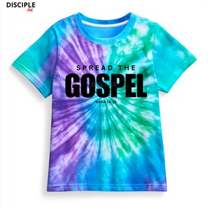 May include: A short-sleeve t-shirt featuring a tie-dye pattern in shades of purple, blue, and green. The front displays the black text SPREAD THE GOSPEL and MARK 16:15. The top left corner includes the brand text DISCIPLE Ink in black lettering.