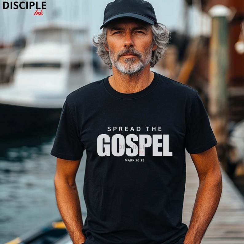 May include: A black short-sleeved t-shirt featuring the white text SPREAD THE GOSPEL and the reference MARK 16:15 printed on the chest. The shirt is paired with a plain black baseball cap, creating a simple and clean look for casual wear.