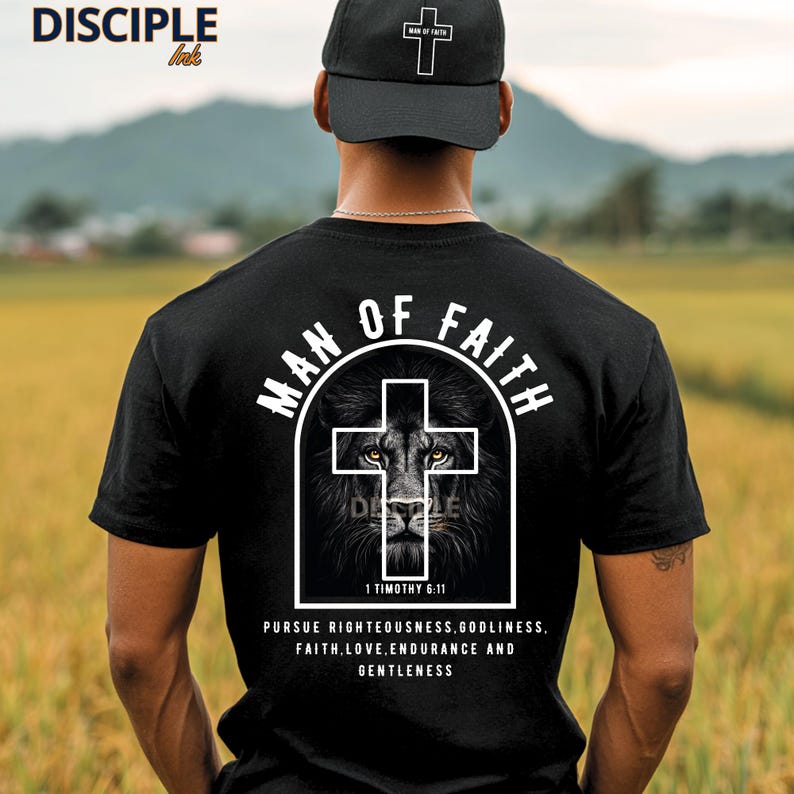 May include: Black t-shirt with a white graphic of a lion inside a cross, the words "MAN OF FAITH" and "1 Timothy 6:11". The shirt also has the text "PURSUE RIGHTEOUSNESS, GODLINESS, FAITH, LOVE, ENDURANCE AND GENTLENESS". A black cap with a white cross is also visible.