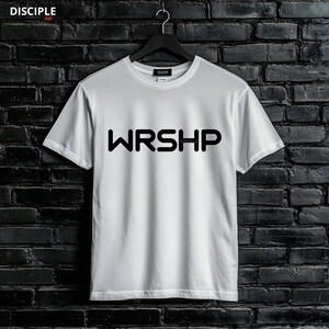 May include: White t-shirt with black text that reads "WRSHIP" with the word "DISCIPLE" in smaller font underneath.