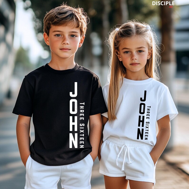 Pode incluir: Duas crian&ccedil;as vestindo camisetas e shorts combinando. Uma crian&ccedil;a est&aacute; vestindo uma camiseta preta, a outra uma camiseta branca. Ambas as camisetas t&ecirc;m o nome "JOHN" impresso verticalmente em branco, com "THREE SIXTEEN" abaixo.