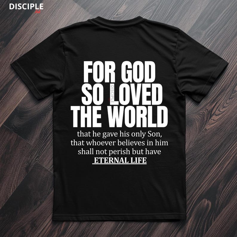 Pode incluir: Camiseta preta com texto branco: "FOR GOD SO LOVED THE WORLD" e um vers&iacute;culo b&iacute;blico. A camisa tamb&eacute;m tem a palavra "DISCIPLE" no topo. O texto continua com "that he gave his only Son, that whoever believes in him shall not perish but have ETERNAL LIFE."