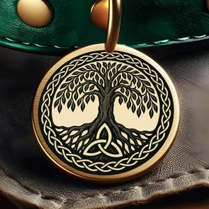 May include: A gold-colored pendant with a black Tree of Life design, featuring a Celtic knot border and a triquetra symbol. The pendant is round and hangs from a gold-colored loop. The background is a dark green and black leather-like material.