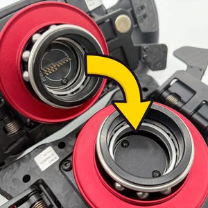 以下が含まれることがあります： 2つの黒と赤の機械部品のクローズアップ。より大きな機械の一部である可能性があります。各コンポーネントは、赤い円形リング、銀色のベアリング、黒い中央部を備えています。黄色の矢印は組み立てを示しています。