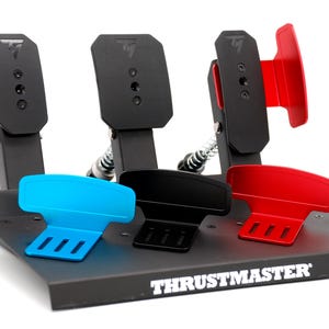May include: A set of black and colored racing pedals with the Thrustmaster logo. The pedals have black bases and colored footrests in blue, black, and red. The pedals are mounted on a black base with springs.
