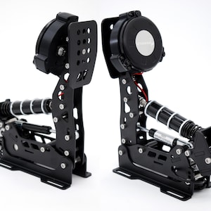 Op de afbeelding: Twee zwarte racepedalen met zilveren en witte accenten. De pedalen hebben een complex mechanisch ontwerp met veren, cilinders en montageplaten. De pedalen zijn ontworpen voor simracen.