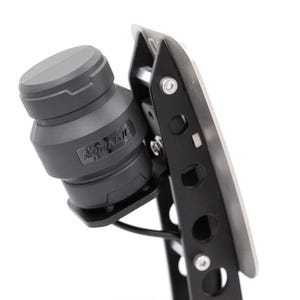 May include: A black and silver metal pedal with a black cylindrical device attached to it. The device has a label that reads "Shift Knob".