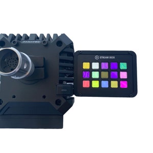 May include: A black Fanatec racing wheel base with a silver connector and a Stream Deck with multi-colored illuminated buttons. The Stream Deck is attached to the side of the wheel base.