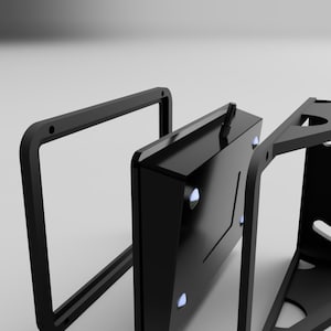 May include: A black, geometric product design with a rectangular frame, a central component with blue accents, and a triangular support structure. The design appears to be a component of a larger product, possibly a stand or a housing.