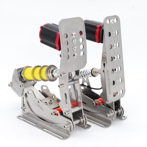May include: A set of silver racing pedals with black and red accents. The pedals have a perforated design and are mounted on a silver base. Yellow springs and a silver rod are also visible.