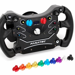 Op de afbeelding: Een zwart en koolstofvezel racestuur met de merknaam "FANATEC" zichtbaar. Het stuur heeft meerdere gekleurde knoppen en draaiknoppen en wordt geleverd met een set verwisselbare gekleurde knoppen. Het stuur is ontworpen voor Xbox.