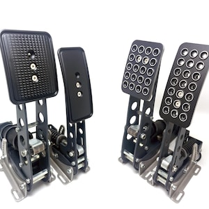 Peut inclure: Un ensemble de trois pédales de course noires avec des cadres métalliques et des positions réglables. Les pédales ont des surfaces texturées et sont conçues pour être utilisées dans un simulateur de course.