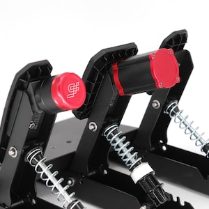 May include: Black and red racing simulator pedals with silver springs. The pedals have a black base and are designed for use in a racing simulator setup. The red caps have a white logo. The image is taken against a white background.