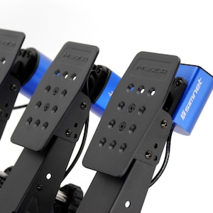 May include: A set of three black metal racing pedals with perforated plates, each featuring the embossed MOZA logo. The pedal assembly includes bright blue cylindrical housings with the white text SIMNET printed on the side of the rightmost unit.