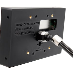 May include: Black Stream Deck 32 Key Module with the text "SIMRACEMODS.COM STREAM DECK 32 KEY MODULE". The device has a silver and black adjustable arm attached. The module has several gold-coloured screw holes.
