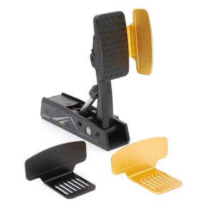 May include: A black racing pedal assembly featuring a textured faceplate and a gold side attachment. Two additional interchangeable pedal faceplates, one in black and one in gold, are positioned in front of the main unit on a white background.