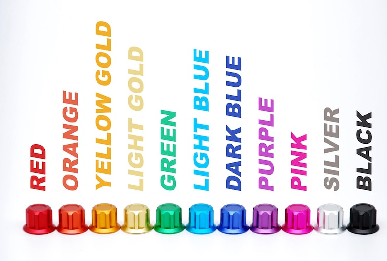 K&ouml;nnte beinhalten: Eine Reihe von elf kleinen, zylindrischen Metallkappen mit geriffelten Seiten in verschiedenen Farben: Rot, Orange, Gelbgold, Hellgold, Gr&uuml;n, Hellblau, Dunkelblau, Lila, Pink, Silber und Schwarz, wobei der Farbname jeweils dar&uuml;ber gedruckt ist.