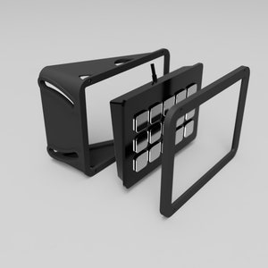 May include: A black electronic device with a grid of silver buttons, disassembled to show its components. The device has a sleek, modern design with a black frame and a triangular base.