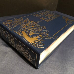 May include: A navy blue hardcover book with gold lettering and illustrations. The title is "The Official DC Comics  Price Guide".