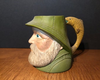 Handmade ceramic coffee cup of a bearded fisherman in rain gear with fish handle 1976