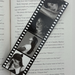 May include: Black and white film strip bookmark featuring four images of a person. The bookmark is rectangular with a series of white perforations along the edges. The images are in grayscale.