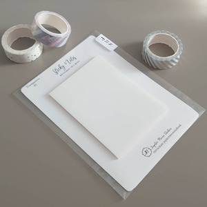 May include: A white sticky note pad with the text "Sticky Notes" and "Rectangle 95 x 140mm" printed on the front. The pad is packaged in a clear plastic sleeve with a white backing card. The backing card has the text "Transparent 01" and "My Jupiter Moon Studio" printed on it. There are three rolls of washi tape in the background, one with a pink and white pattern, one with a silver and white pattern, and one with a blue and white pattern.