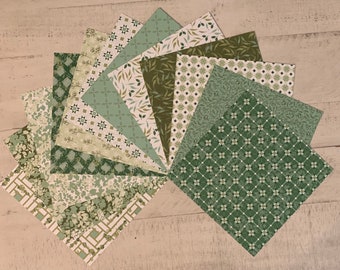 May include: A collection of square paper sheets arranged in a fan shape, featuring various shades of green and white. The patterns include geometric tiles, botanical leaf prints, floral motifs, and lattice designs in different green tones.