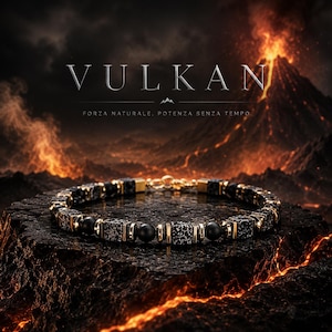 May include: A beaded bracelet featuring alternating black and white speckled cube beads, smooth matte black round beads, and metallic gold-toned spacers. The bracelet includes a gold-toned lobster clasp closure and is displayed against a volcanic landscape.