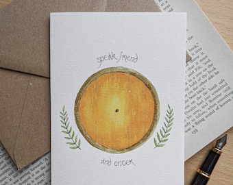 May include: A greeting card featuring a watercolor illustration of a round, yellow door with a brown frame. The text "speak friend and enter" is written above and below the door. Green leaves flank the door.