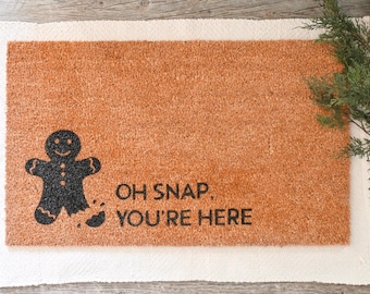 May include: A brown coir doormat with a black gingerbread man graphic and the text "Oh Snap. You're Here".