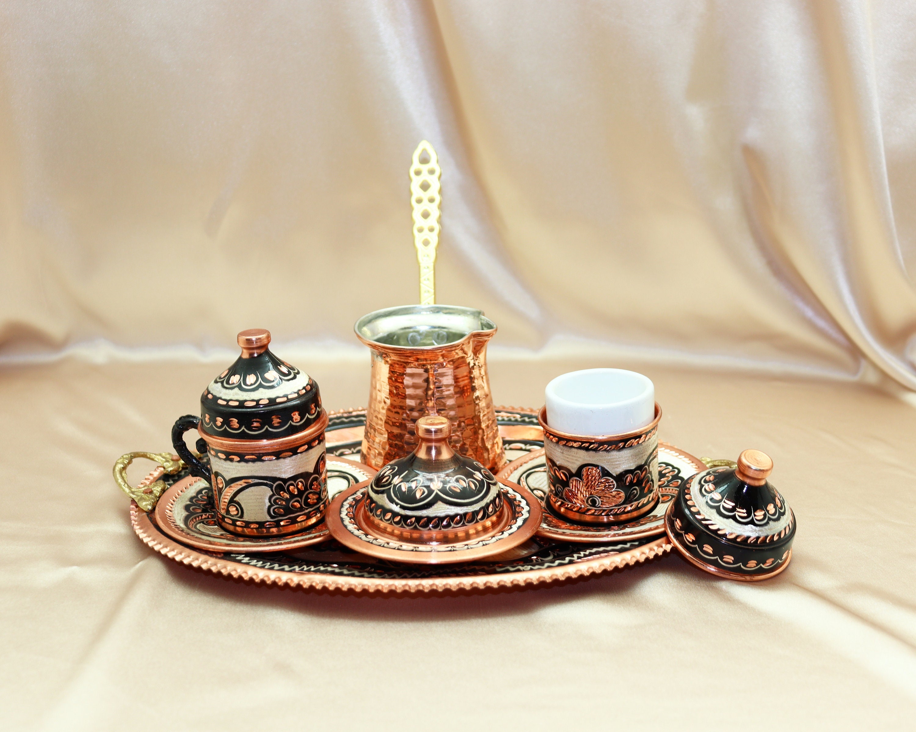 Cafetera turca y tazas en bandeja de madera