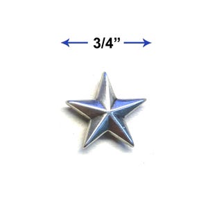 May include: A silver-colored star-shaped object, measuring 3/4 inch across, is displayed against a white background. The star has five points and a slightly reflective surface, suggesting a metallic material. The image is a close-up, highlighting the star's details.