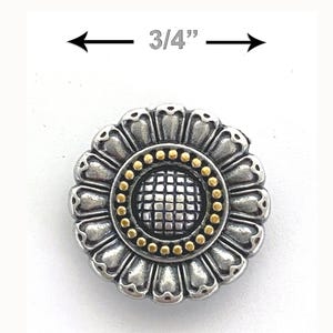 May include: A silver and gold metal button with a flower design. The button is 3/4 inches in diameter.