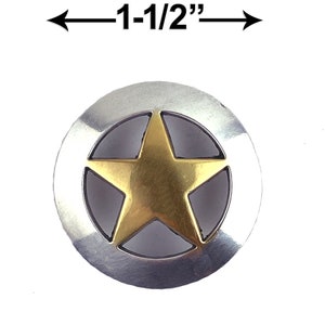 May include: A silver-toned metal button with a gold star in the center. The button is approximately 1-1/2 inches in diameter. The star is a five-pointed design, and the button has a circular shape.