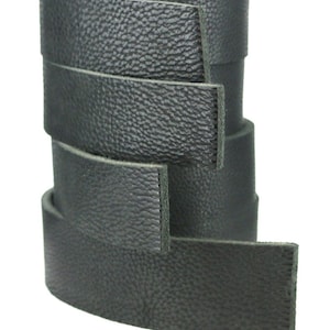 May include: A roll of black leather straps, stacked and ready to be used for crafting projects.