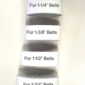 May include: Four white leather belt loops with different sizes marked: "For 1-1/4" Belts", "For 1-3/8" Belts", "For 1-1/2" Belts", and "For 1-3/4" Belts".
