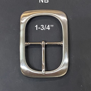 May include: Silver metal belt buckle with a 1-3/4 inch opening. The buckle is smooth and has a rounded rectangular shape.