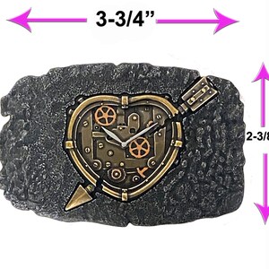 May include: A gray stone heart-shaped clock with a steampunk design. The clock face is a gold heart with gears and an arrow piercing through it. The clock measures 3-3/4 inches wide and 2-3/8 inches tall.