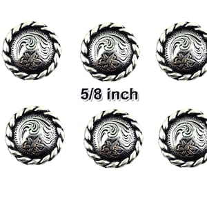 May include: Six silver-toned metal buttons with a rope-like border and a floral design. The buttons are 5/8 inch in diameter.