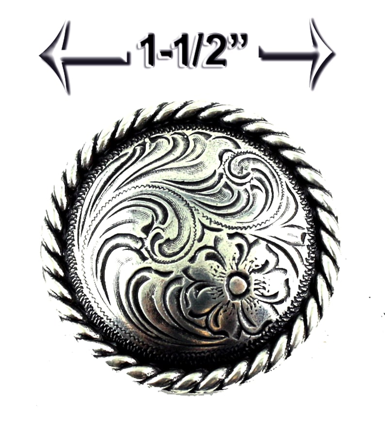 May include: Silver-toned metal belt buckle with a rope-like border and a floral design. The buckle measures 1-1/2 inches in diameter.