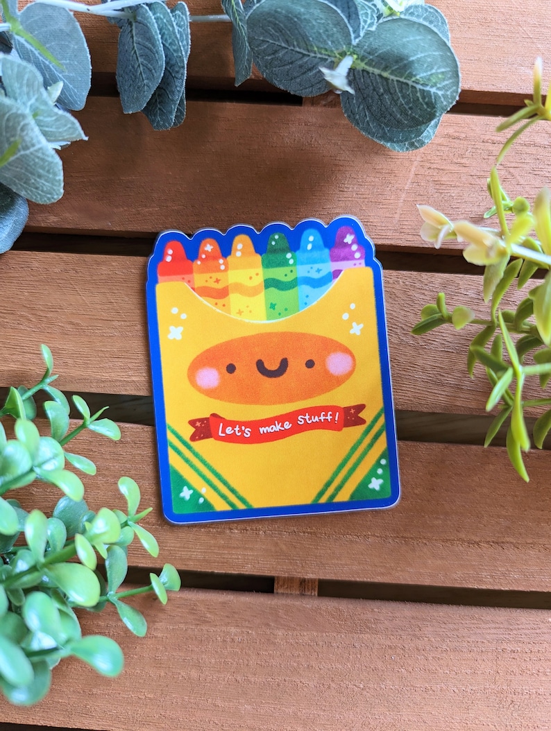 May include: A yellow box with a smiling face and rainbow crayons inside. The box says "Let's make stuff!"