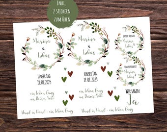 May include: White paper with wedding-themed stickers. The stickers feature floral wreath designs with names and dates, along with phrases like "Our Day" and "Hand in Hand." Includes a green circle with text.