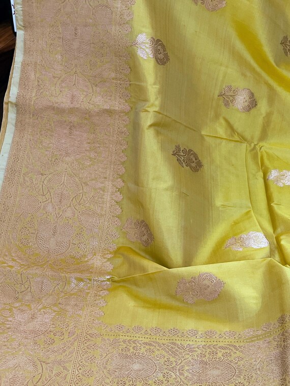 Golden yellow color banarasi saree with golden Zari flower motif.