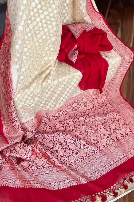 Pure banarasi khaddi georgette saree in off white and red color.