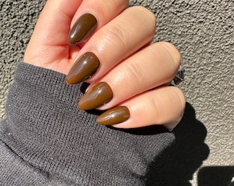 Prensa de color de otoño marrón avellana en las uñas