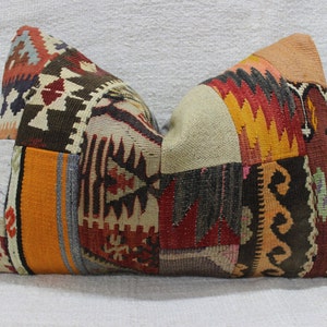 Könnte beinhalten: Rechteckiges Patchwork-Kissen mit einer Vielzahl von geometrischen Mustern und Farben. Das Kissen weist eine Mischung aus Orange-, Rot-, Braun- und Beigetönen auf, wodurch ein strukturiertes und optisch ansprechendes Design entsteht. Dieses dekorative Kissen eignet sich für die Inneneinrichtung.